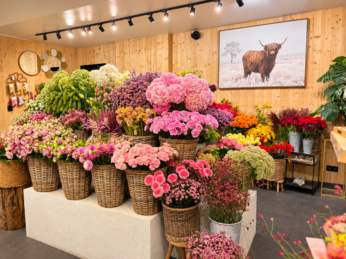 Étal de fleurs coupées en boutique — paniers de pivoines, hortensias et gerberas chez La Rose des Sables
